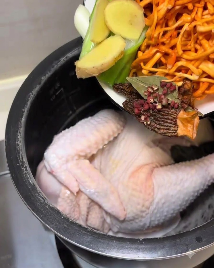 Pouring the prepared aromatics and mushrooms into the cooker pot with the chicken.