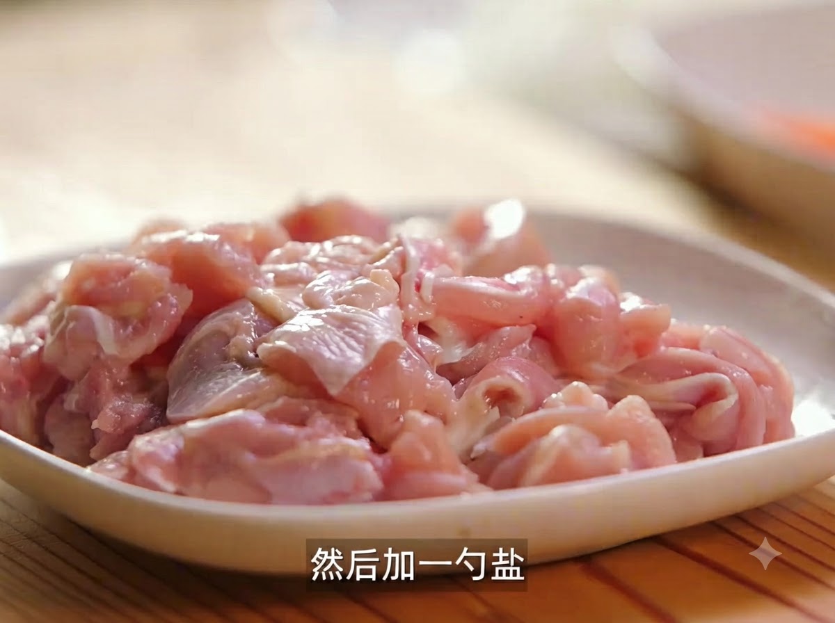 A plate of raw chicken pieces seasoned with salt and black pepper ready for marination.