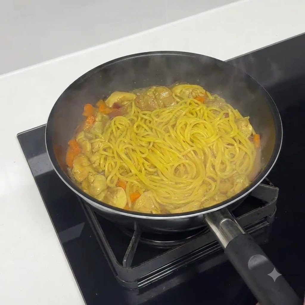 Pasta simmering on medium-high heat to reduce and thicken the sauce.