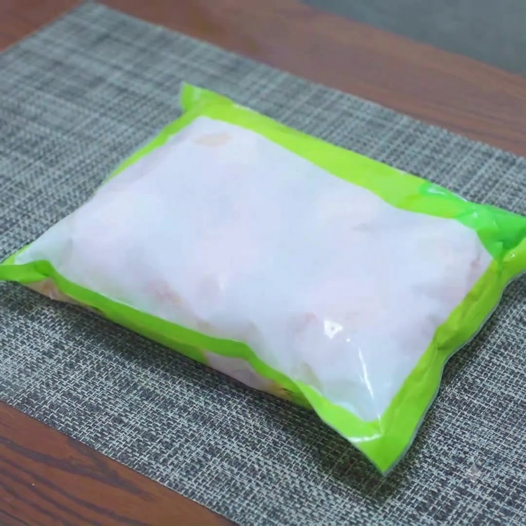 Frozen chicken drumsticks soaking in a bowl of salted water for quick thawing.