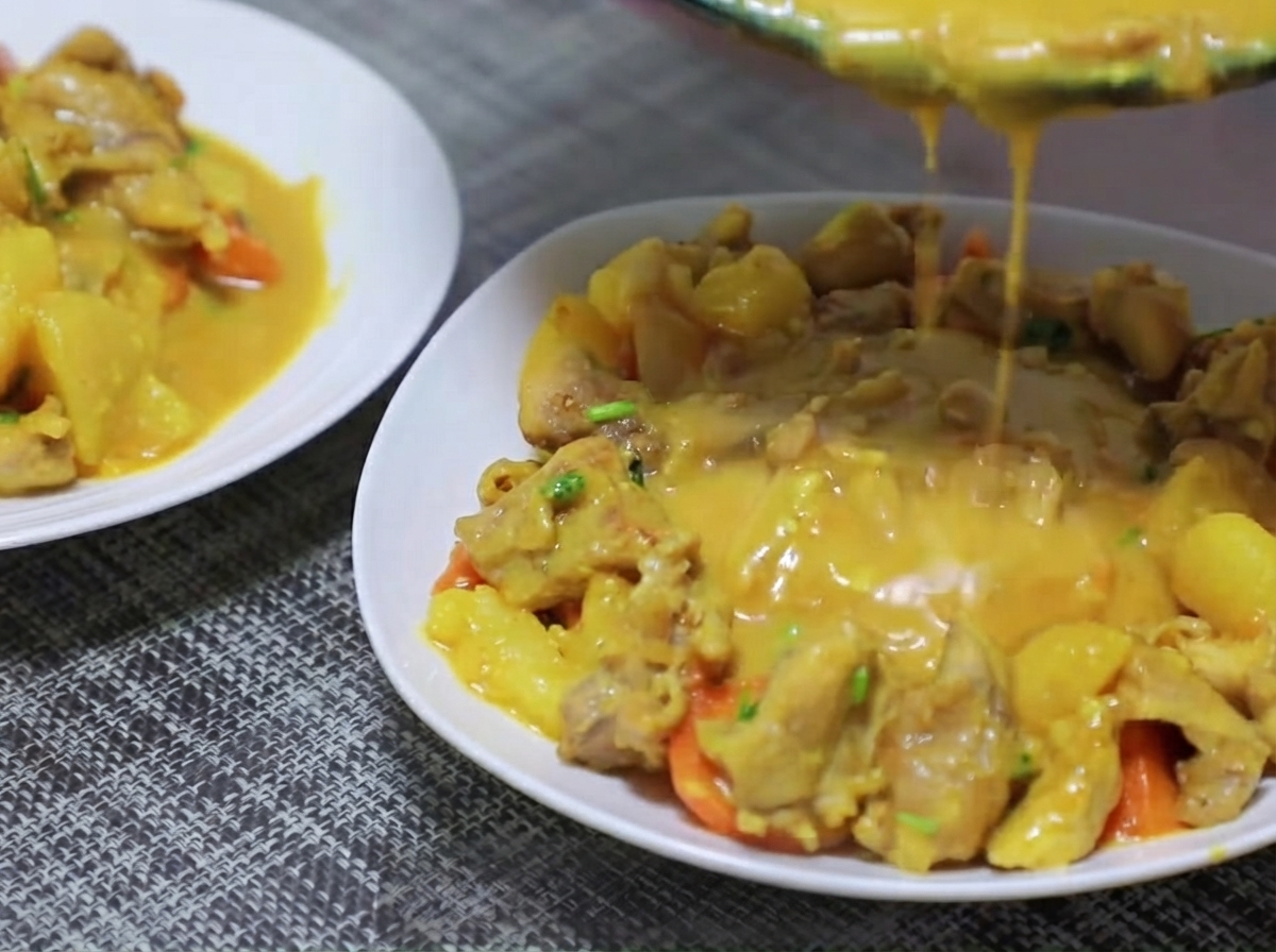 Potato and carrot pieces being added into the pan and stir-fried with the curry base.