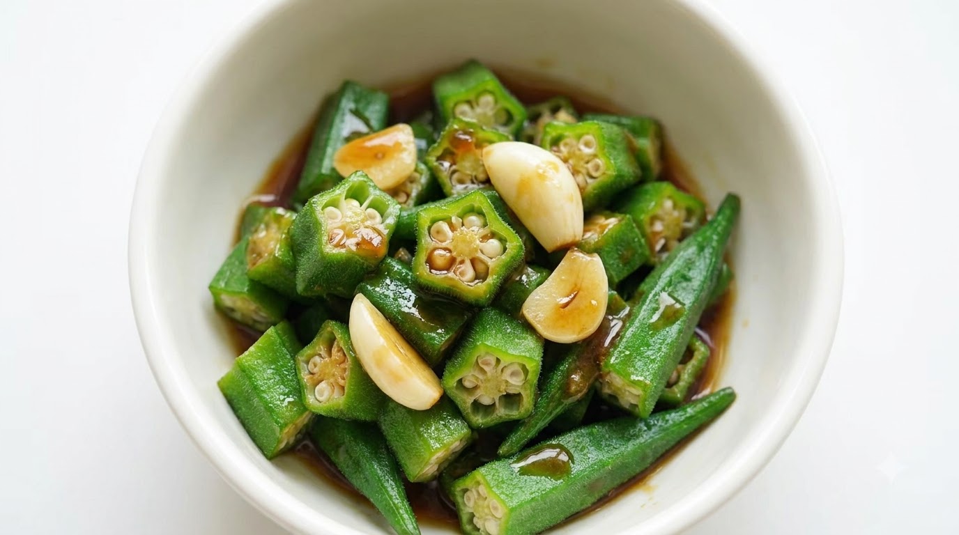 A bowl of sliced green okra topped with garlic and a rich savory brown sauce