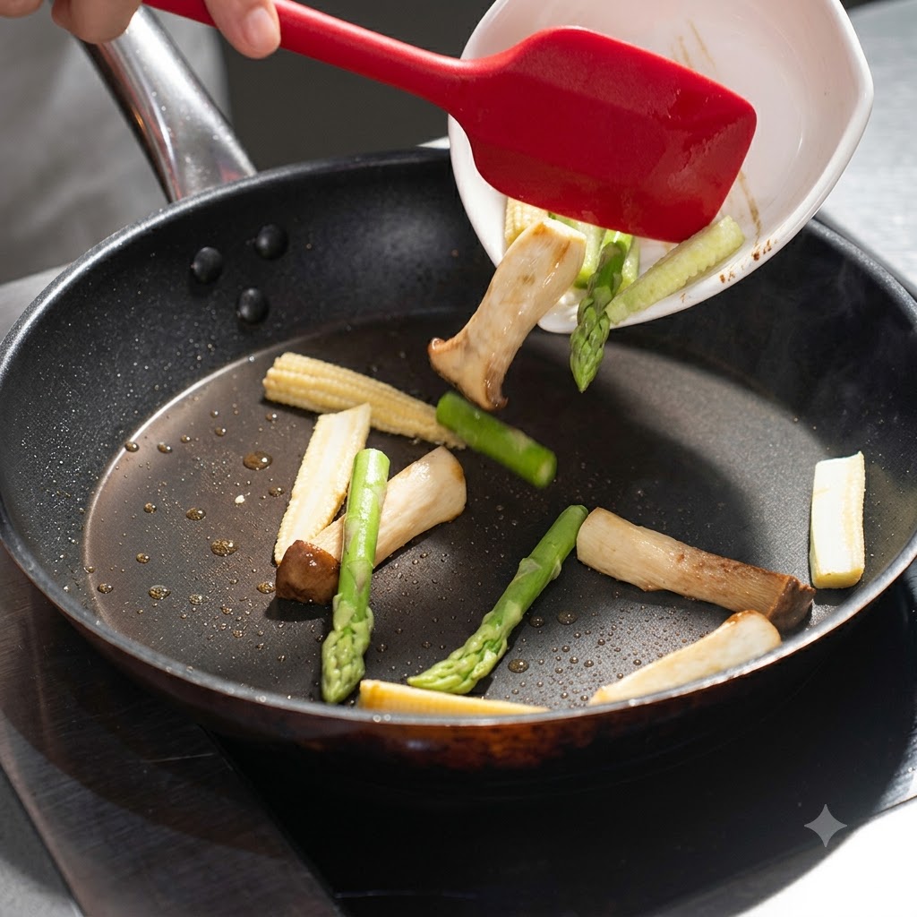 Asparagus and baby corn being poured from a white dish into the frying pan with mushrooms.