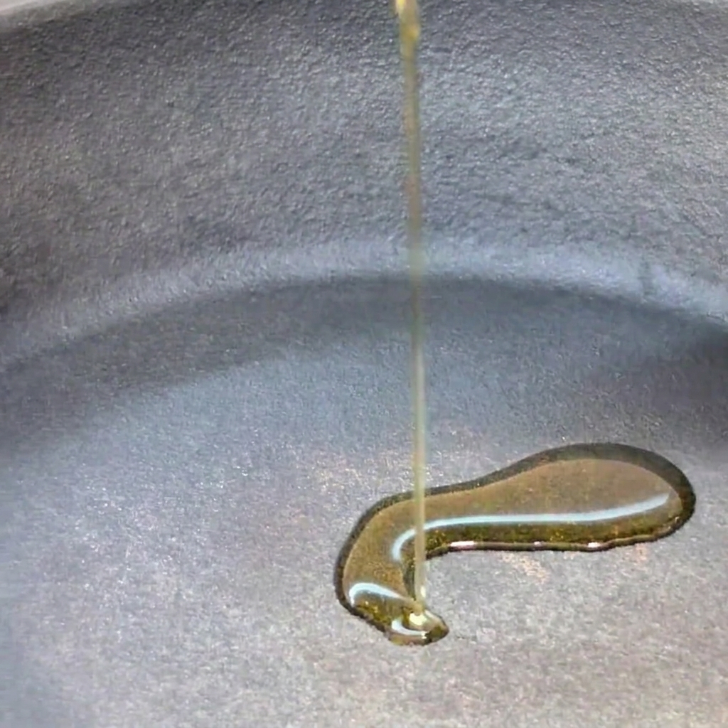 Extra virgin olive oil being poured into a cold pan.