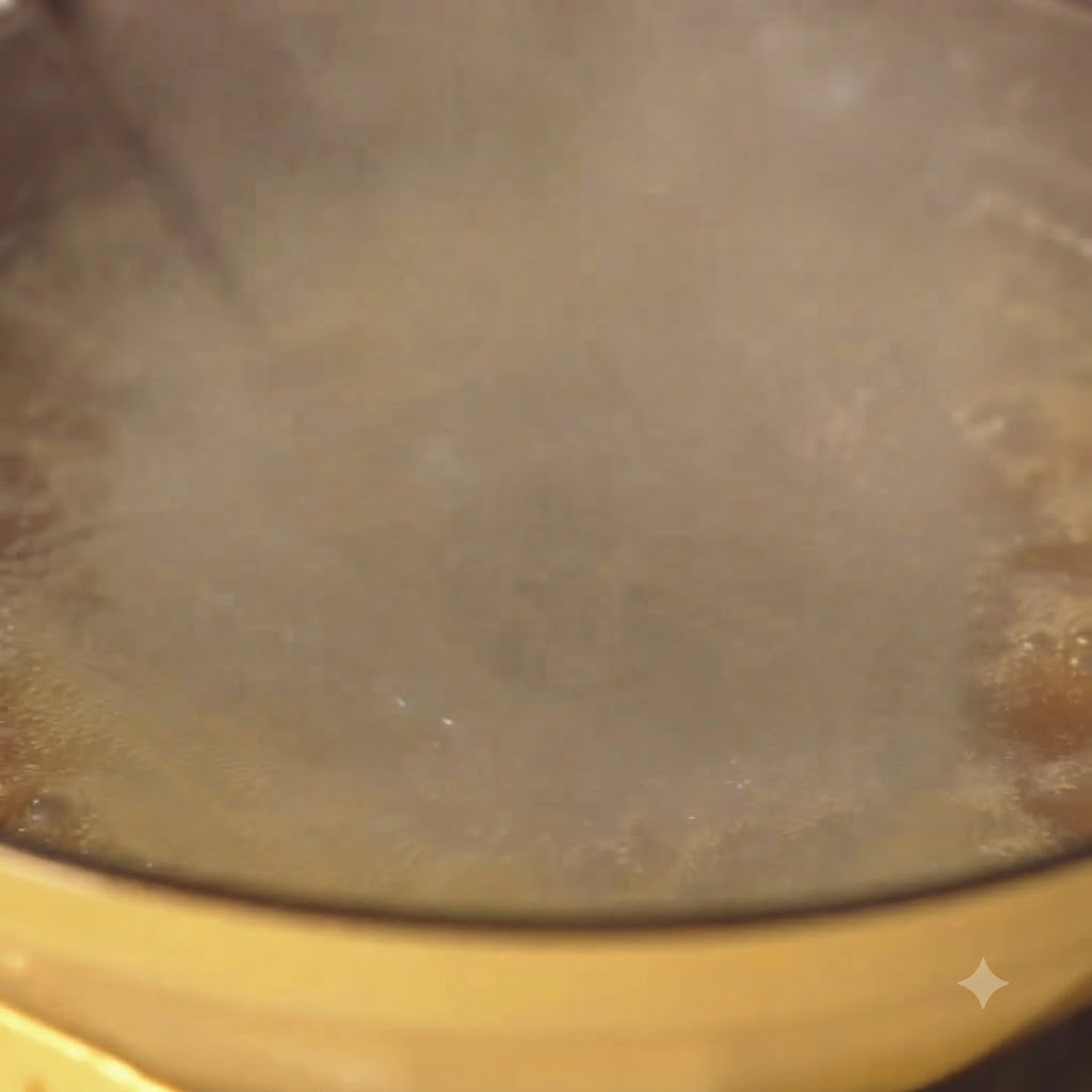 Spaghetti boiling vigorously in a yellow pot of water with steam rising.