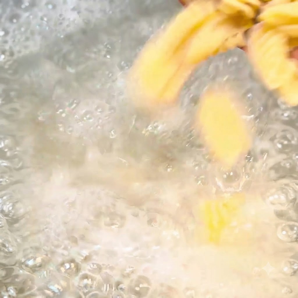 Spiral pasta pieces boiling vigorously in a pot of bubbling salted water.