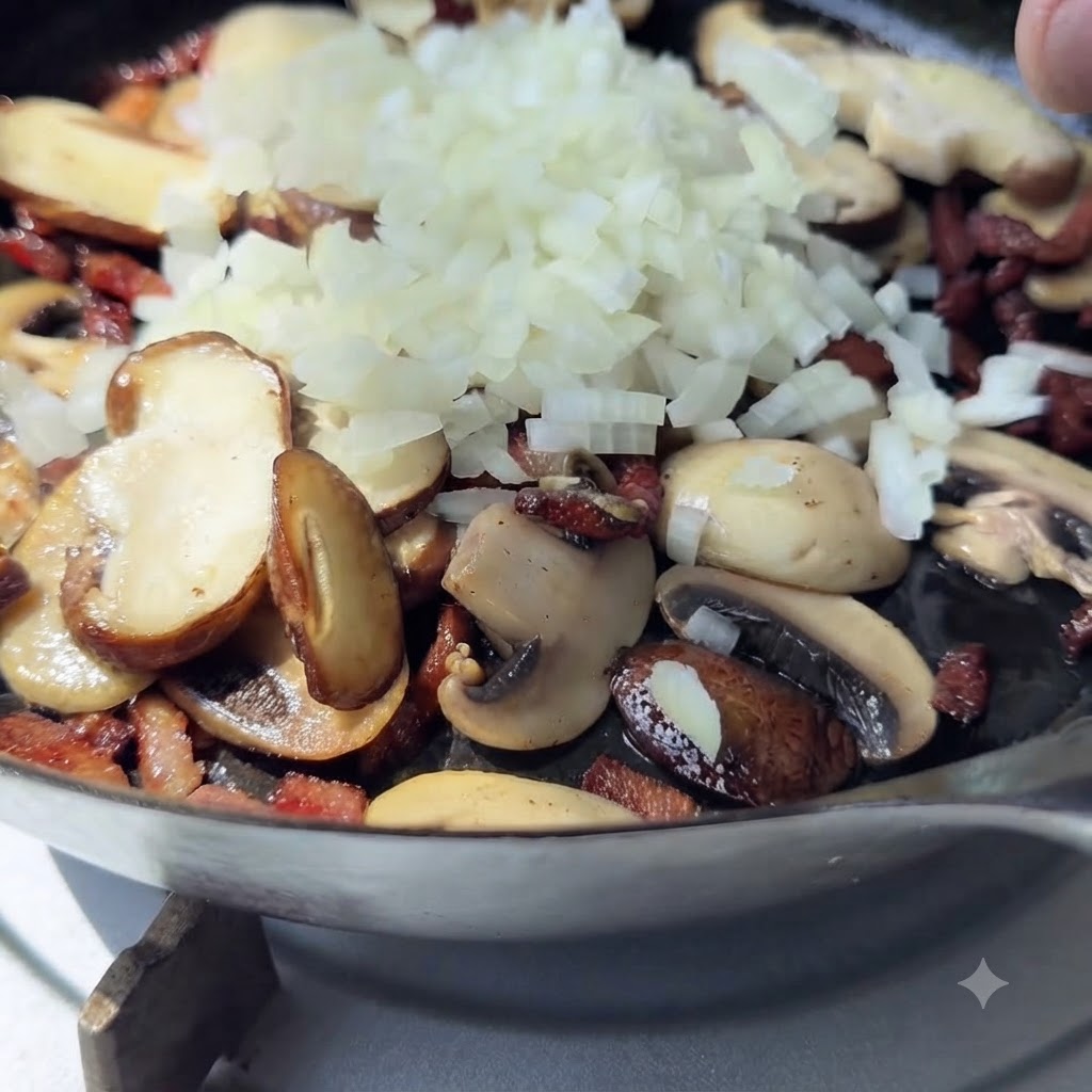 A pile of freshly diced white onions sitting on top of cooked mushrooms and bacon in a pan.