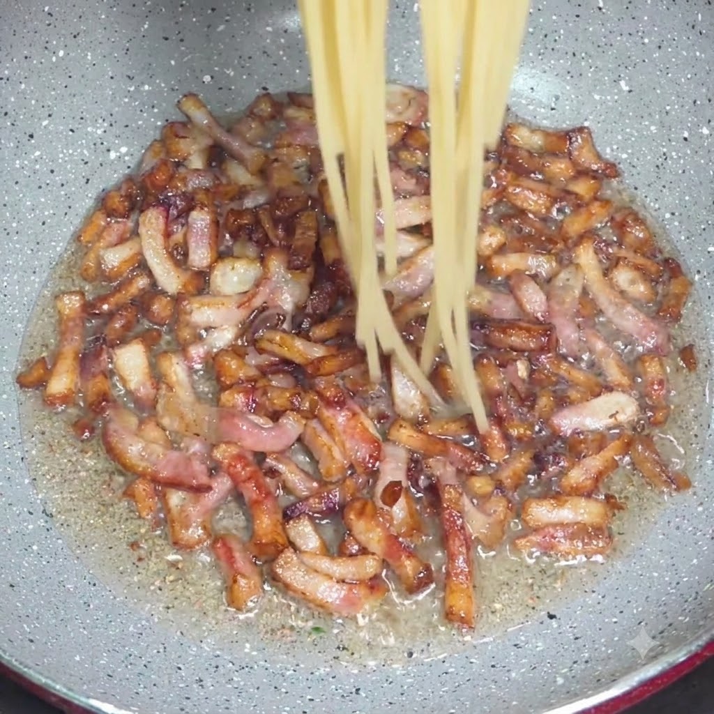 Cooked spaghetti noodles being dropped from tongs into a pan with crispy guanciale pieces.