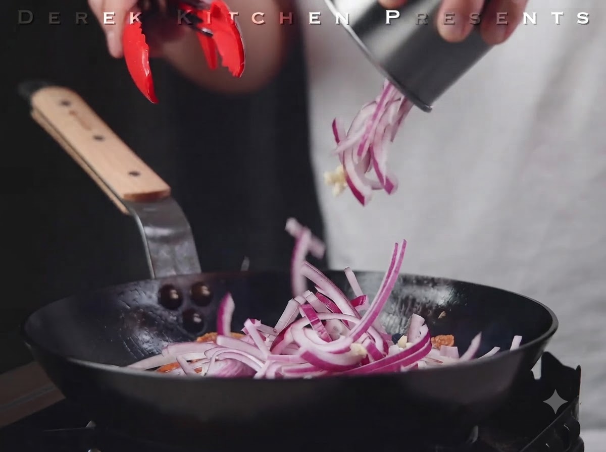 Sliced red onions and garlic being poured into the pan over the salami.
