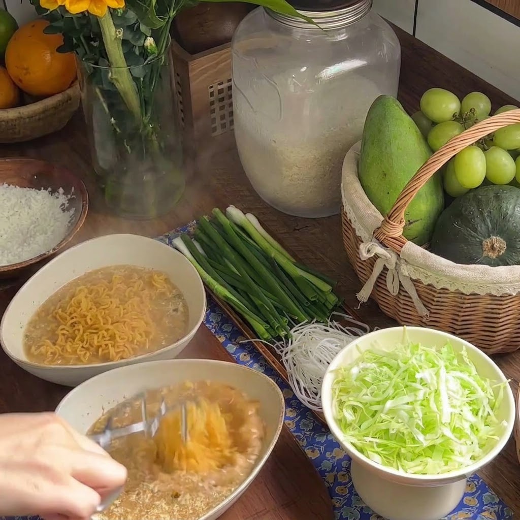 Cooked wavy instant noodles being placed into a bowl filled with creamy broth.
