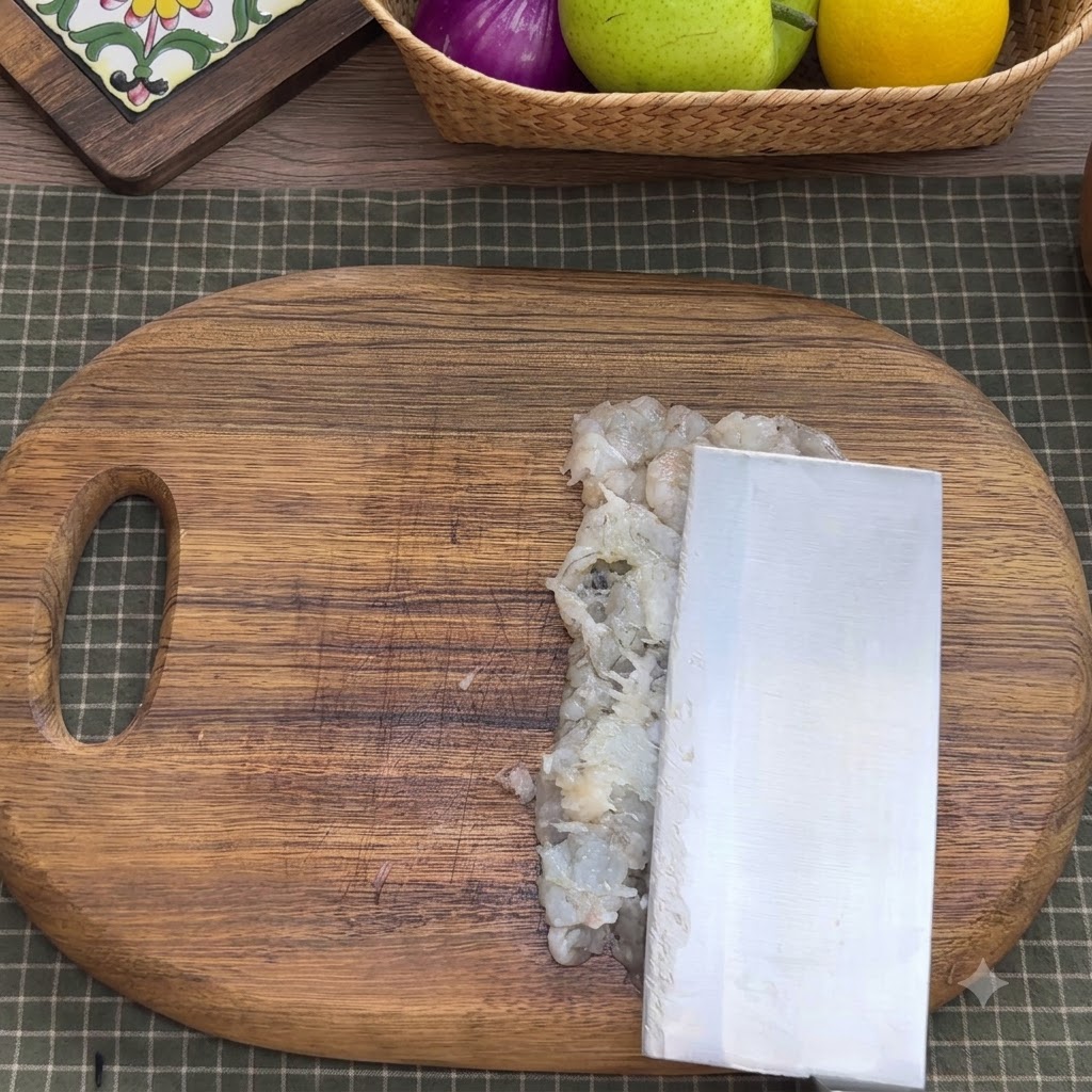 Chopped shrimp meat in a metal mixing bowl with seasonings, egg whites, starch, and water.