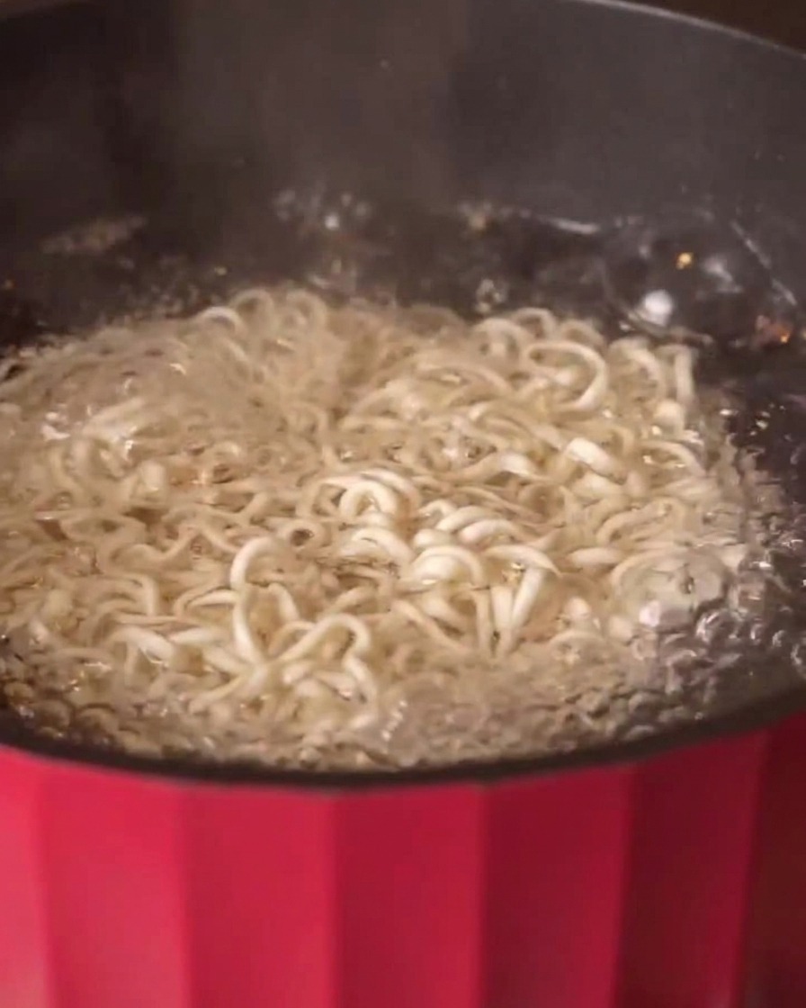Multigrain noodles boiling in a pot of hot water.