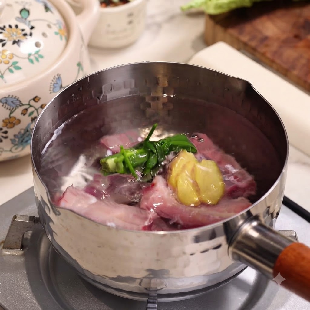 Raw pork ribs boiling in a stainless steel pot with scallions and ginger slices.