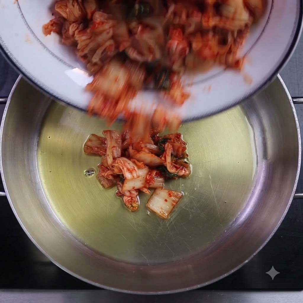 Chopped kimchi and chili powder being poured into an oiled cooking pot.