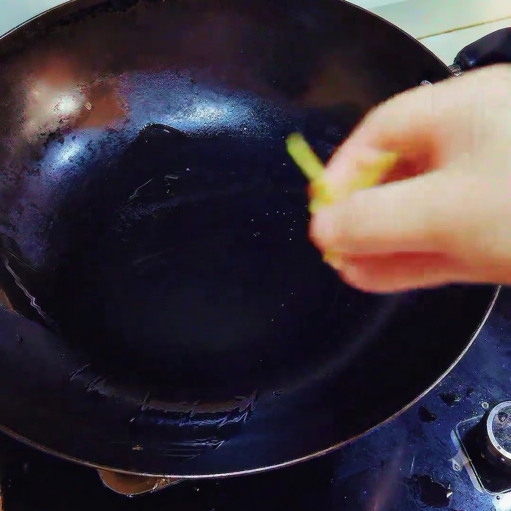 Ginger and garlic pieces being dropped into a wok containing melted lard over heat.
