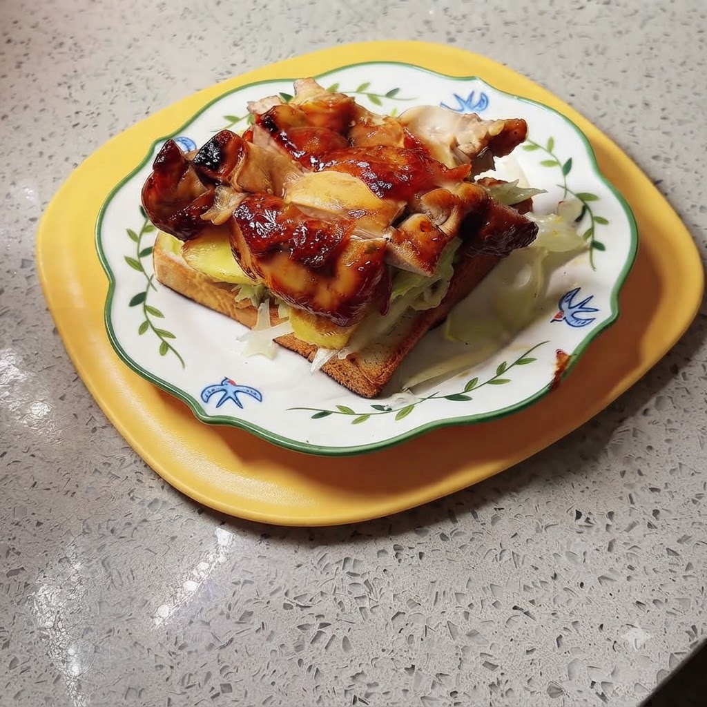 A finished teriyaki chicken and pineapple sandwich plated on a yellow tray, ready for sauce and serving.