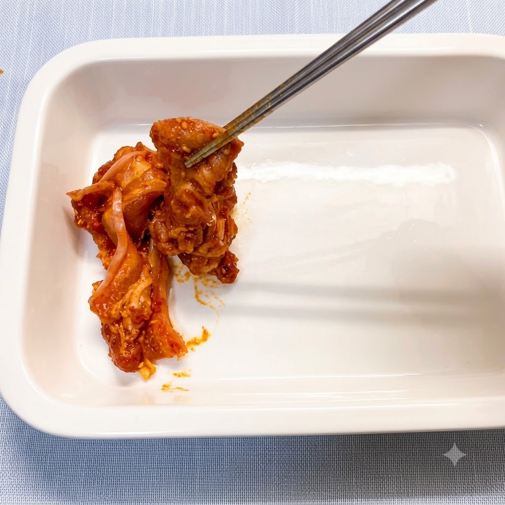 Marinated pork belly slices being placed individually into a clean white ceramic baking dish with chopsticks.