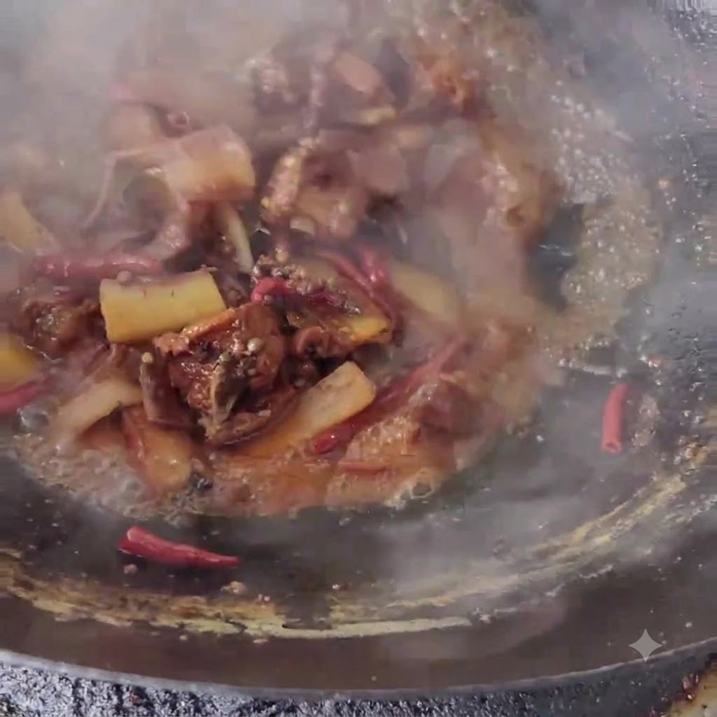 Pork belly strips stir-frying in a wok with sauce and aromatic ingredients.