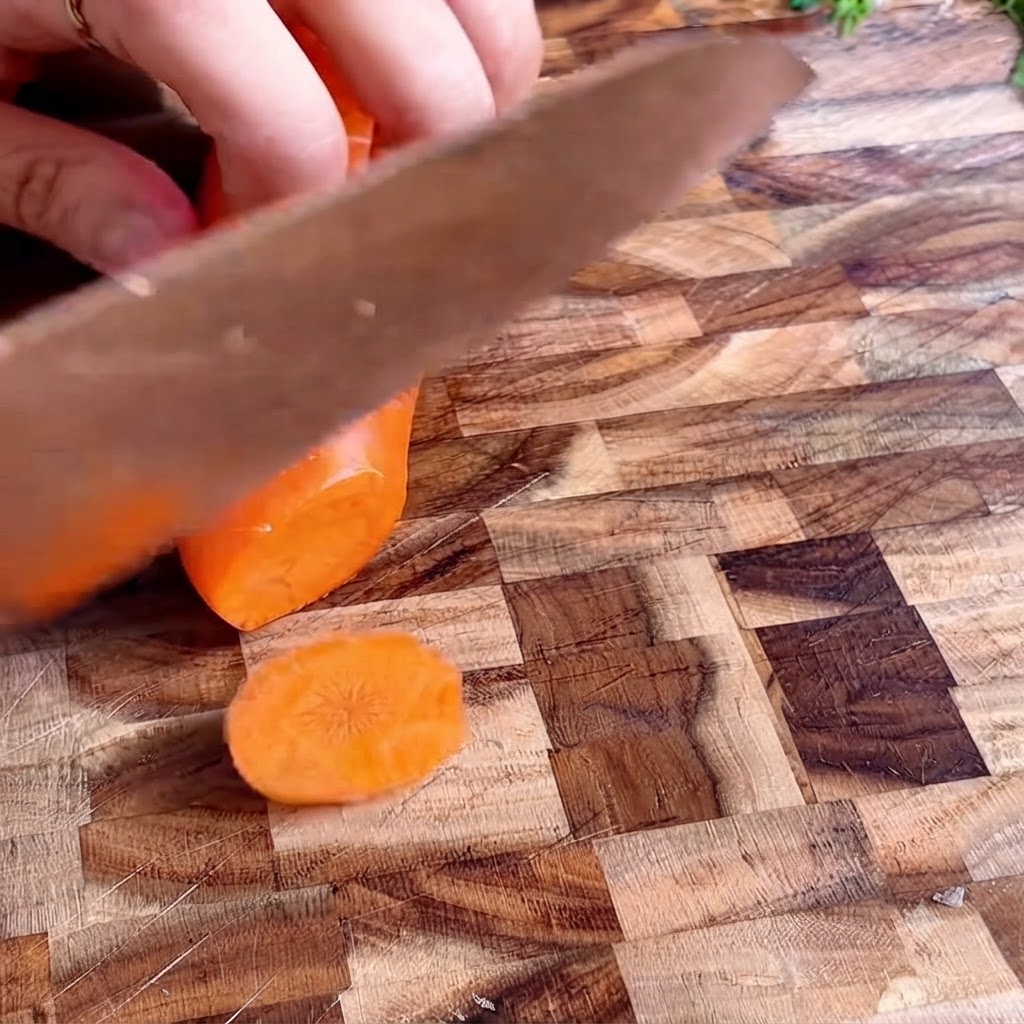 Carrot rounds neatly arranged on a wooden cutting board.