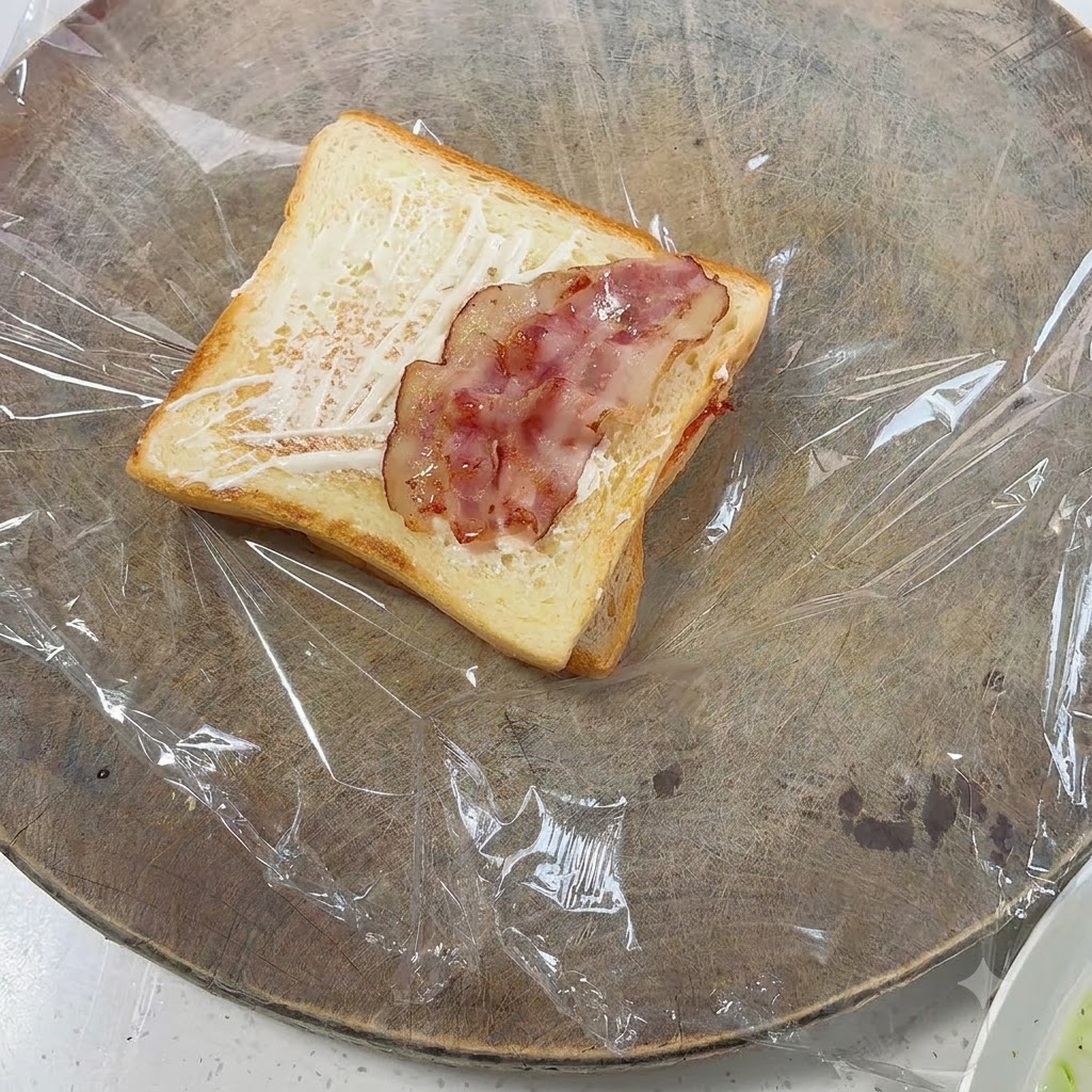 Pieces of cooked bacon laid out on top of the toasted bread.