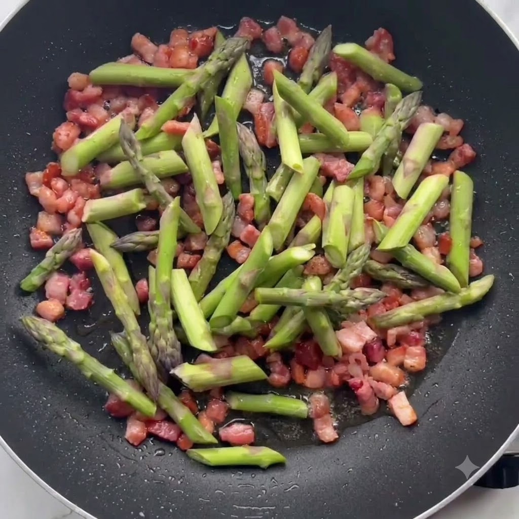 Green asparagus pieces sautéing alongside crispy bacon in a frying pan.