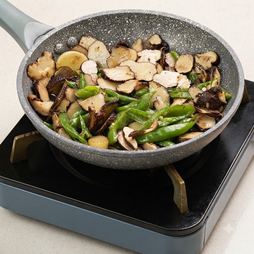 A hand sprinkling salt into a skillet filled with sliced truffles and green peppers cooking over heat.