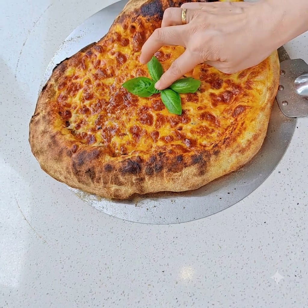 Salami slices being placed over the cheese layer of a prepared pizza.