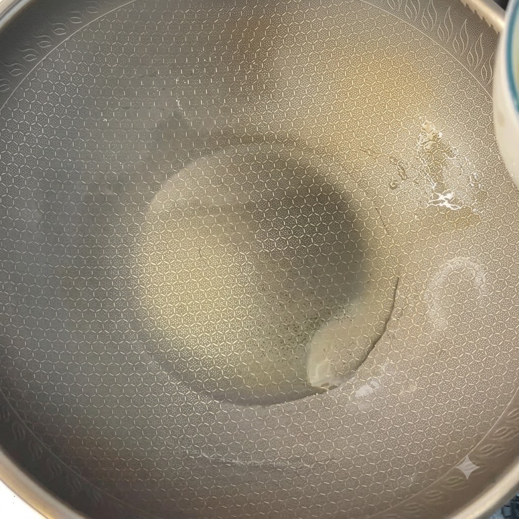Scrambled eggs being cooked in a heated wok using chopsticks.