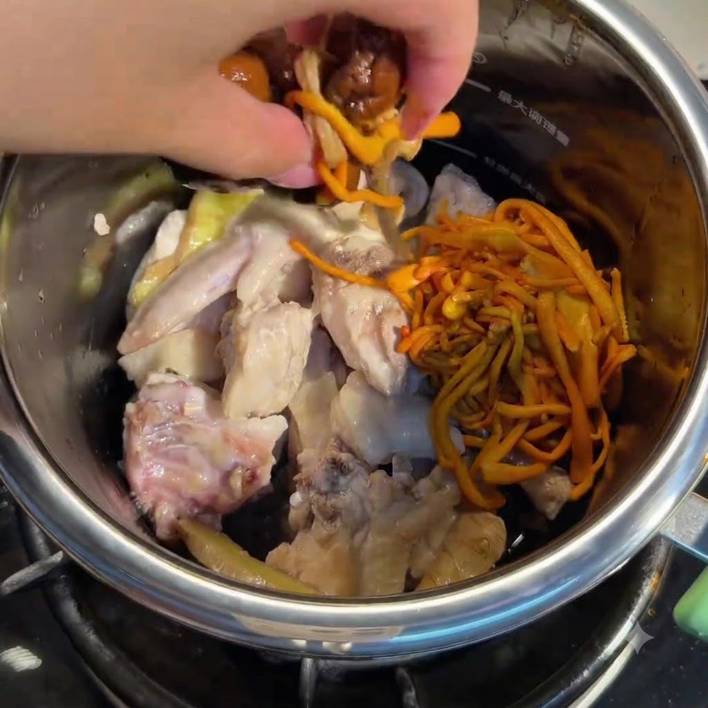 Hand adding soaked mushrooms and cordyceps flowers into the pot with chicken.
