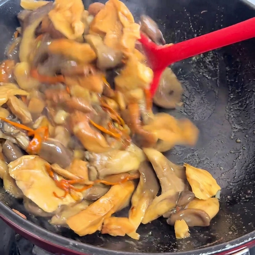 Liquid being poured into the pan over the cooked mushrooms.