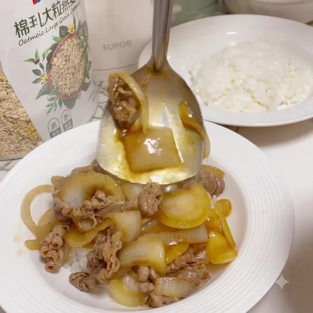 A metal serving spoon scooping up cooked beef and glazed onions from a pan to ladle over a white plate filled with cooked white rice.