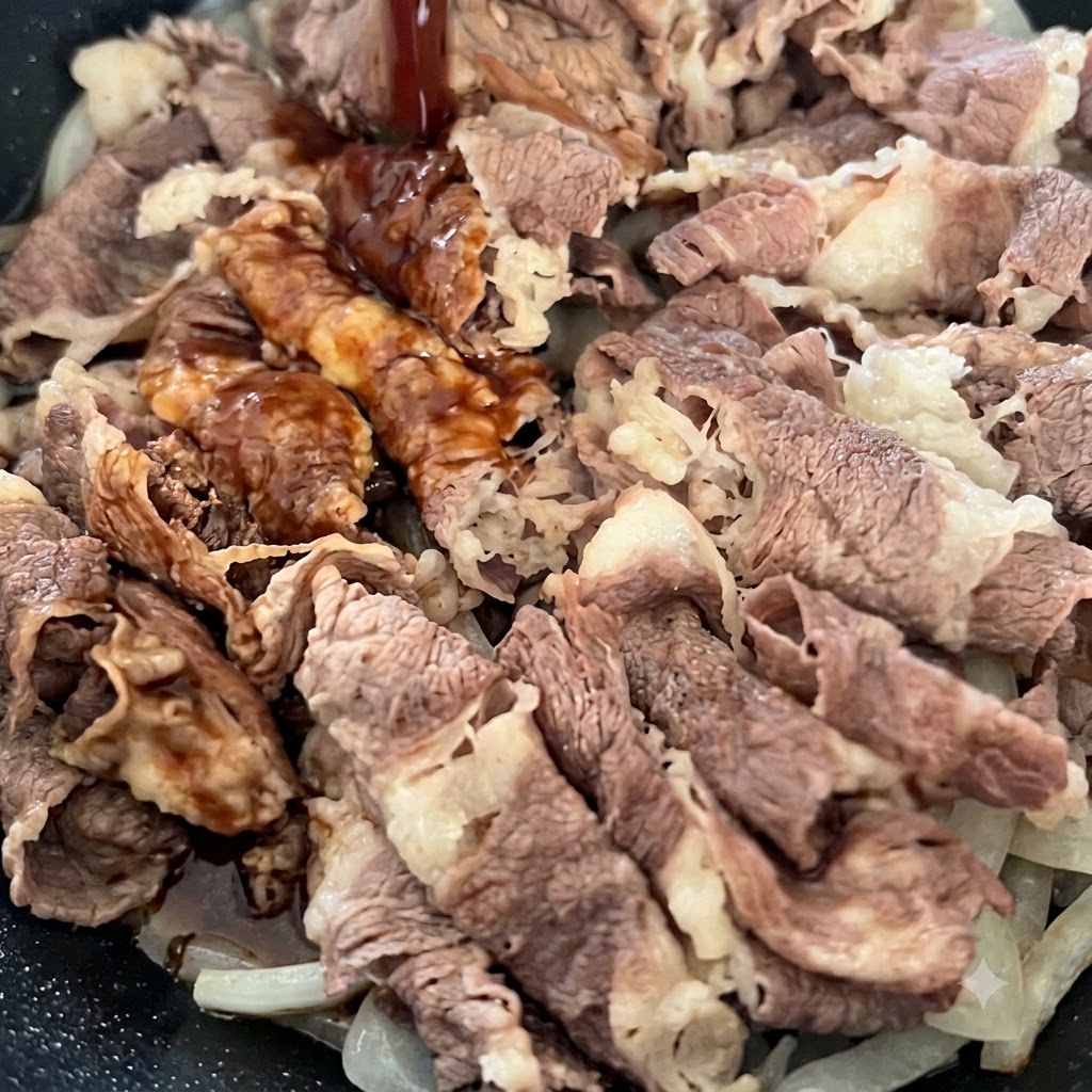 Dark savory sauce being poured from above onto cooked beef slices and onions in a frying pan.