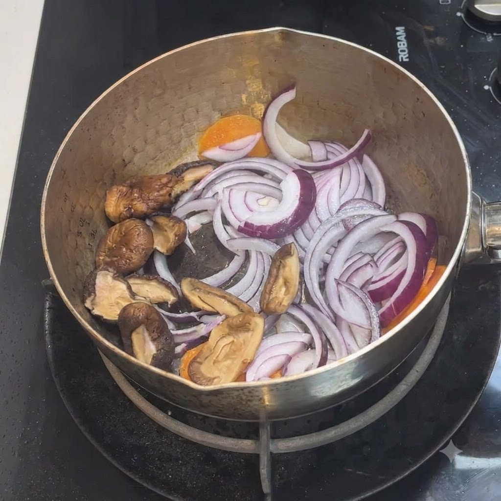 Sliced shiitake mushrooms placed inside the pot with the existing mixture of onions and carrots.