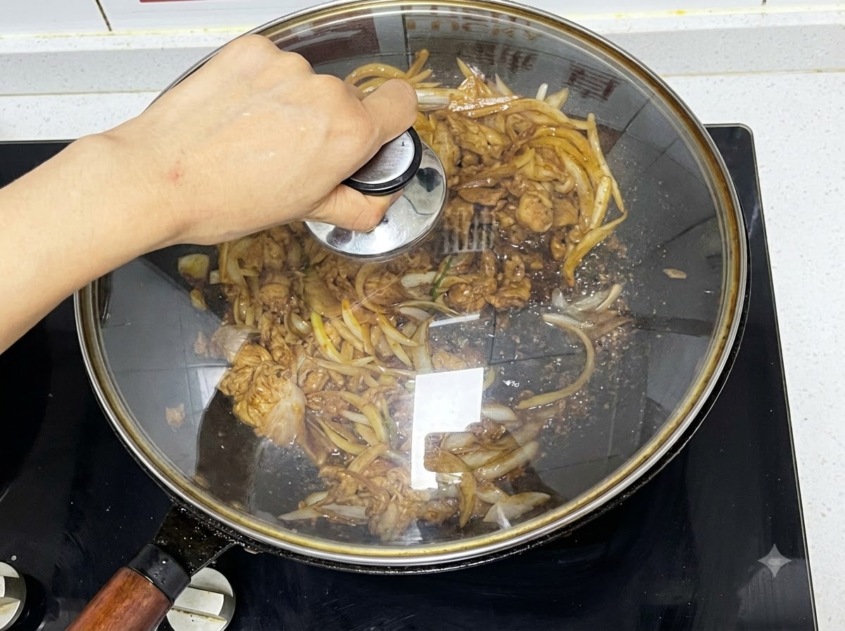 A glass lid being placed over a wok containing simmering beef and onions.