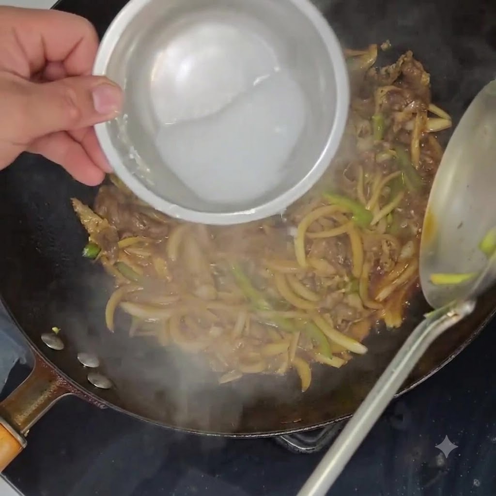 Potato starch slurry being poured from a small bowl into a wok filled with simmering beef and vegetables.