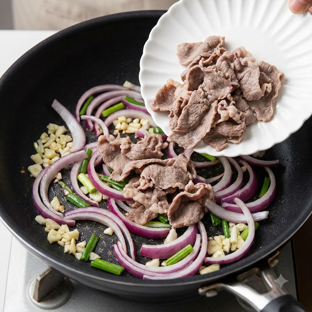 Blanched sliced beef rolls being transferred from a white plate into a pan containing sauteed red onion slices.