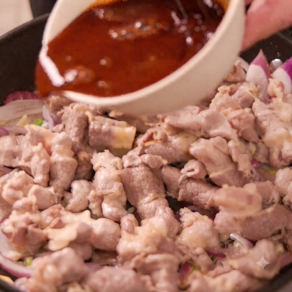 A bowl of dark sauce being poured into a pan filled with beef rolls and sliced red onions.