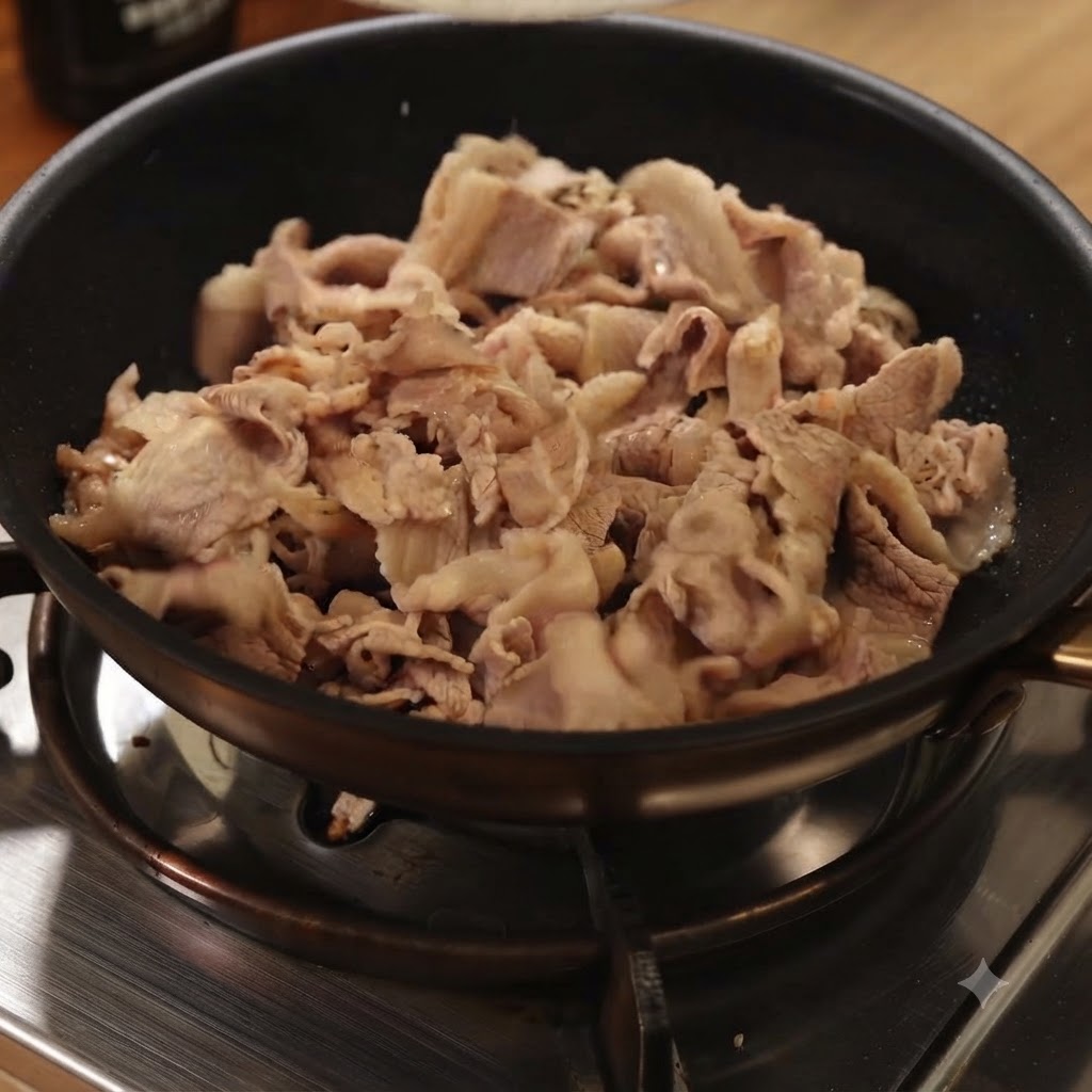 Blanched beef slices being stir-fried in a black pan on a gas stove.