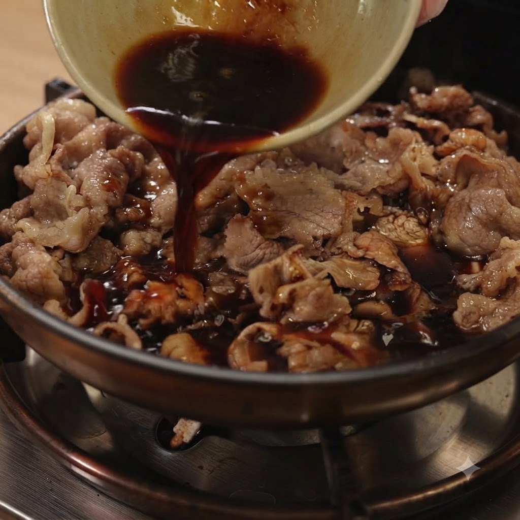 Dark teriyaki sauce being poured from a small bowl into a pan filled with sliced beef and red onions.