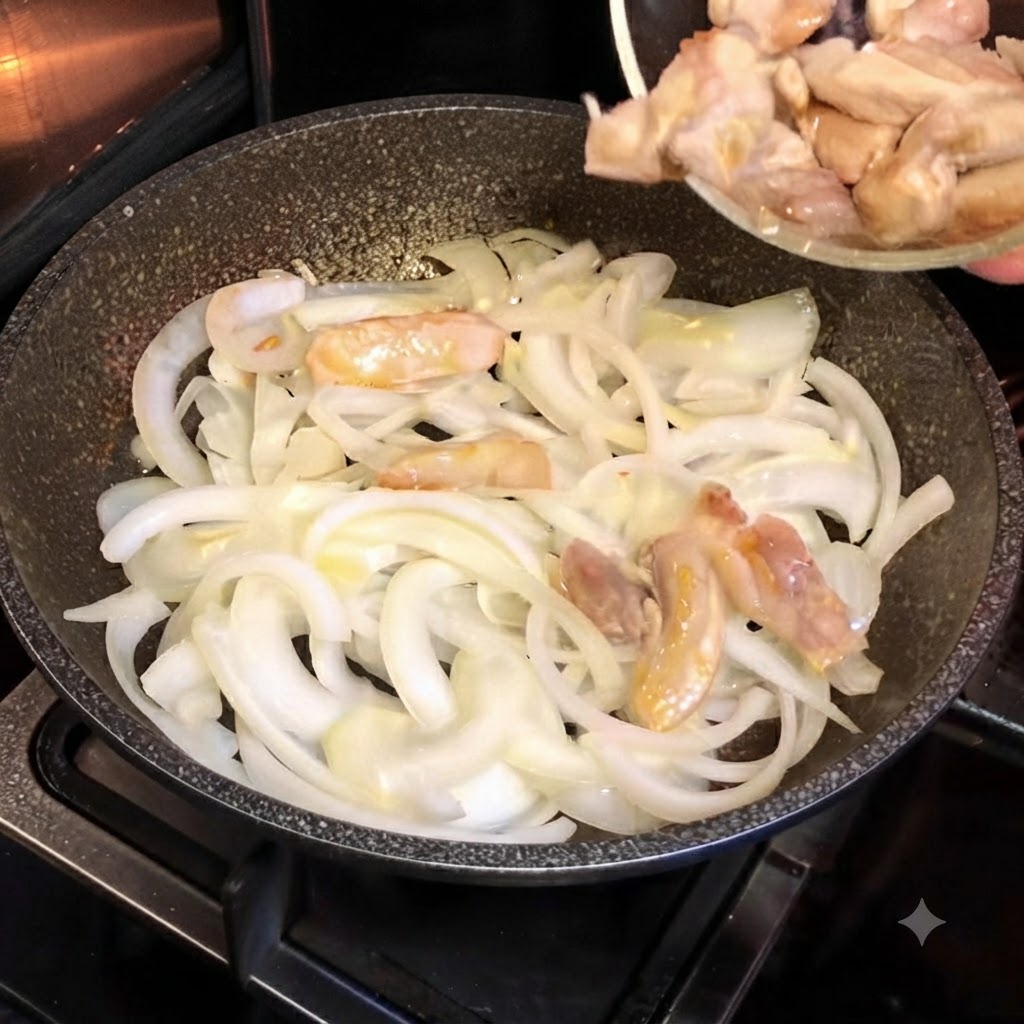 Partially cooked chicken pieces being poured from a small glass bowl into a hot skillet filled with sliced white onions.