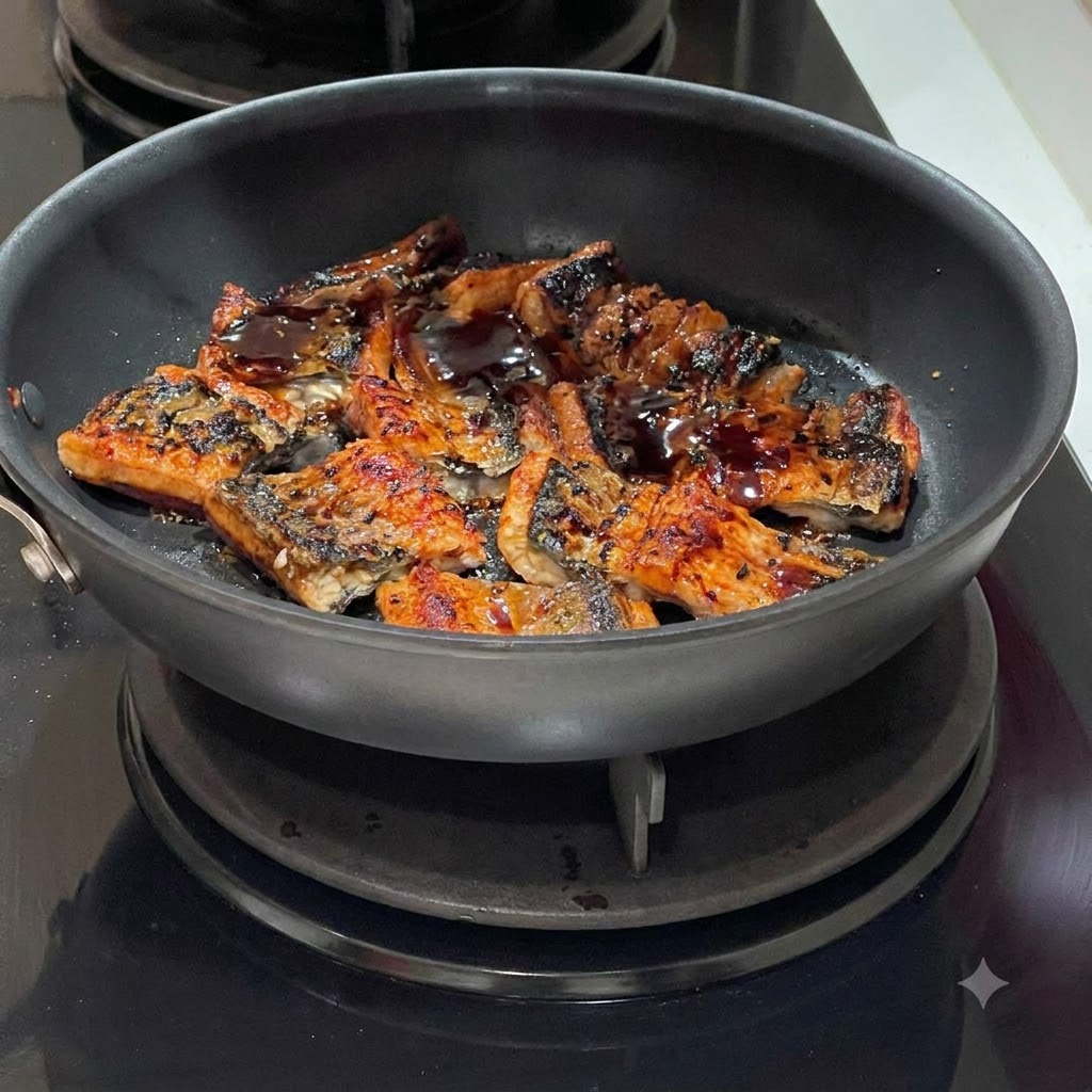 Dark sauce being drizzled over sizzling eel segments in a frying pan.