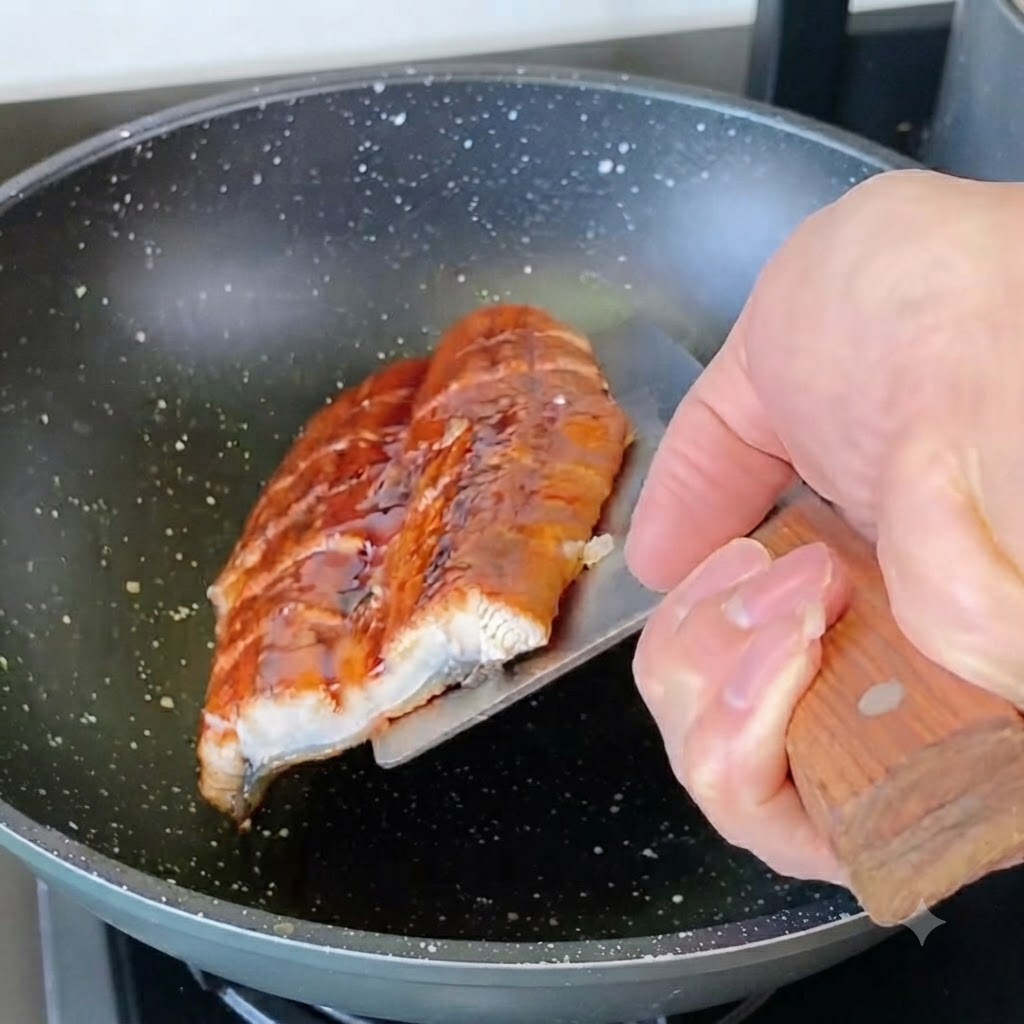 Sliced eel pieces being pan-fried in a skillet.