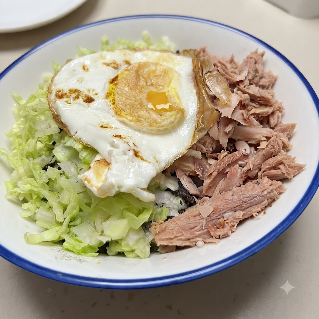 A finished rice bowl loaded with rice, tuna, vegetables, and a fried egg on top.