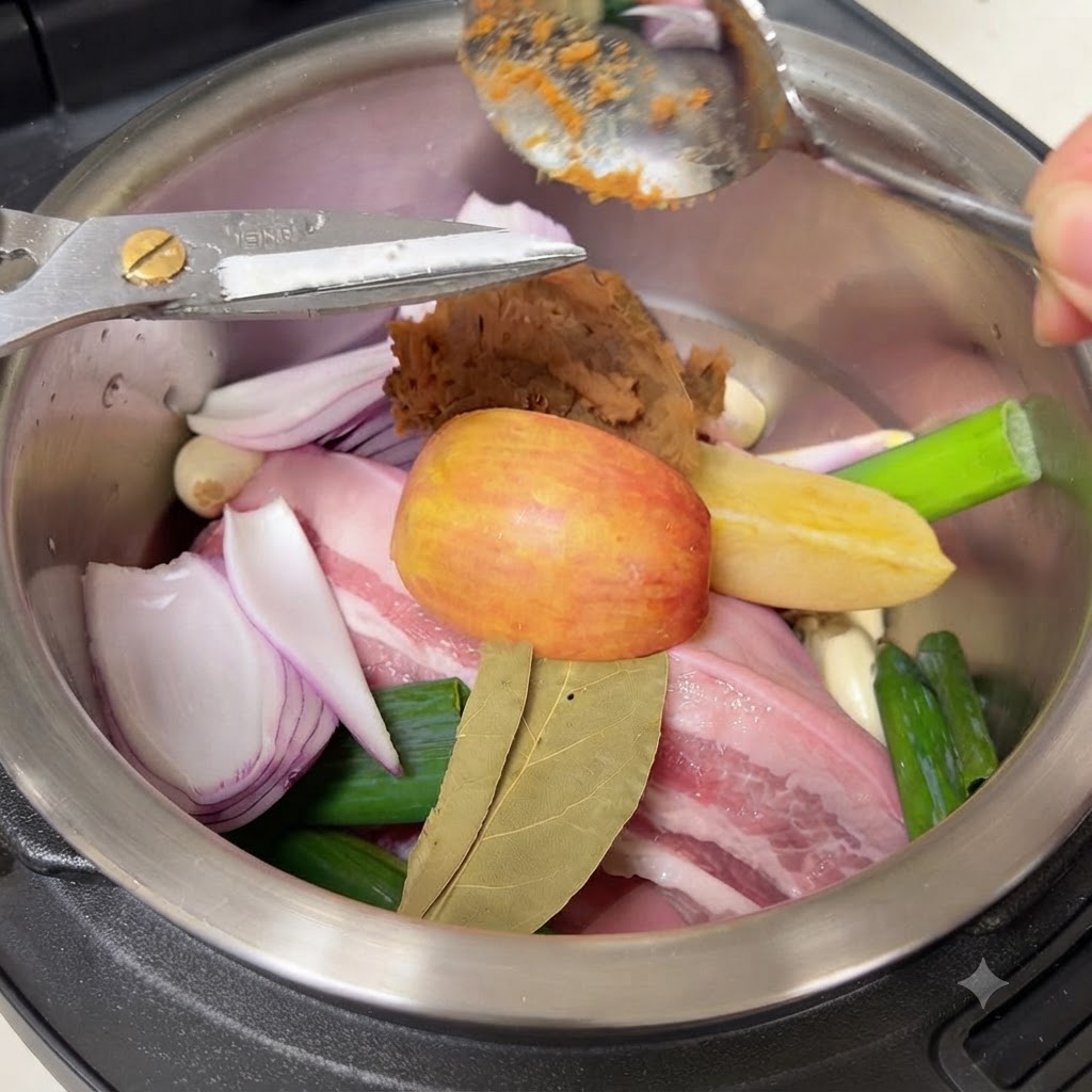 A spoonful of brown Korean soybean paste being added onto the ingredients inside the cooking pot.