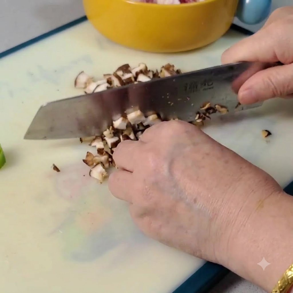 Raw shiitake mushrooms being sliced and diced into small pieces on a cutting board.