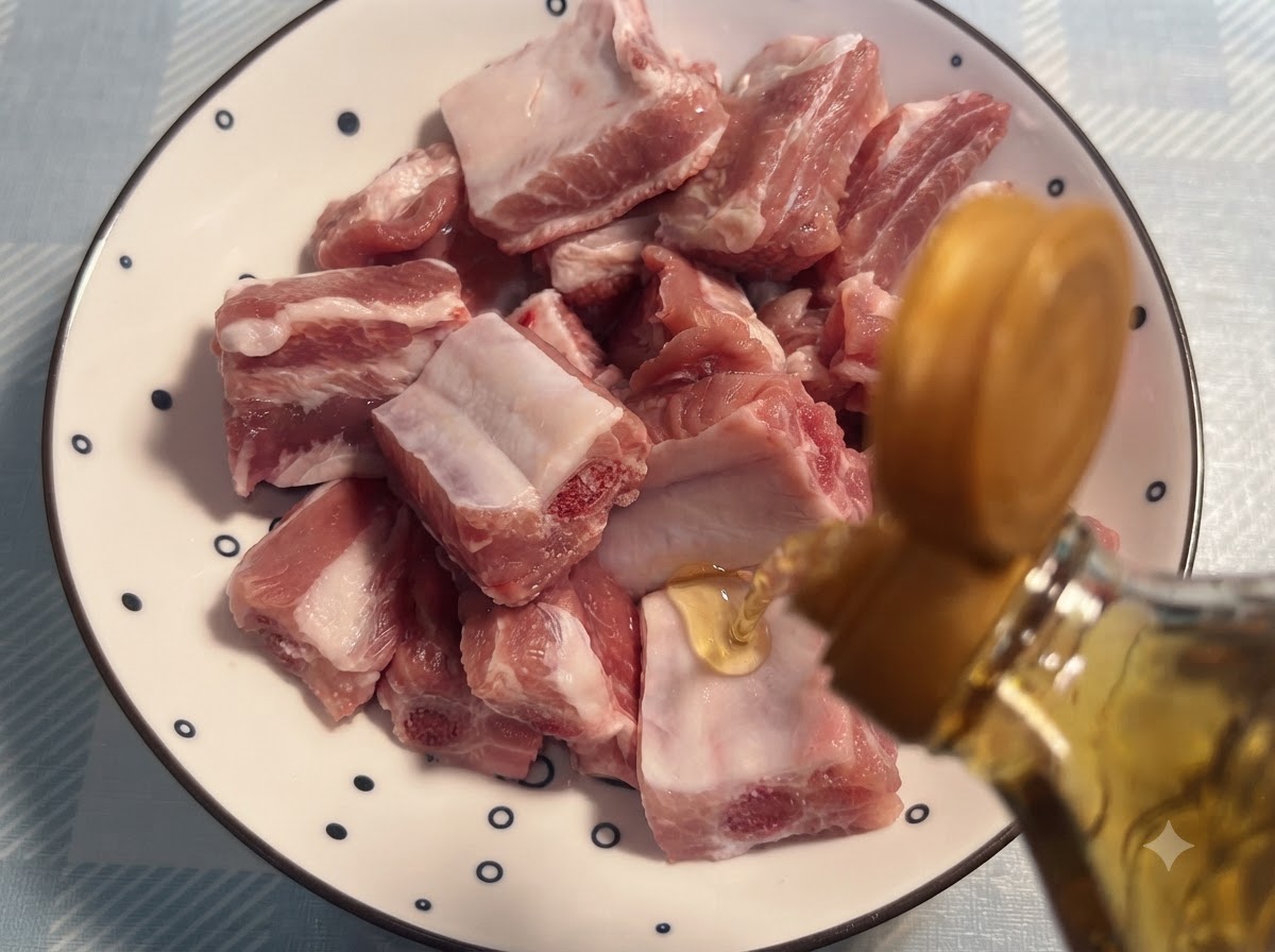 Cooking wine being poured from a bottle onto raw pork ribs arranged on a patterned plate.