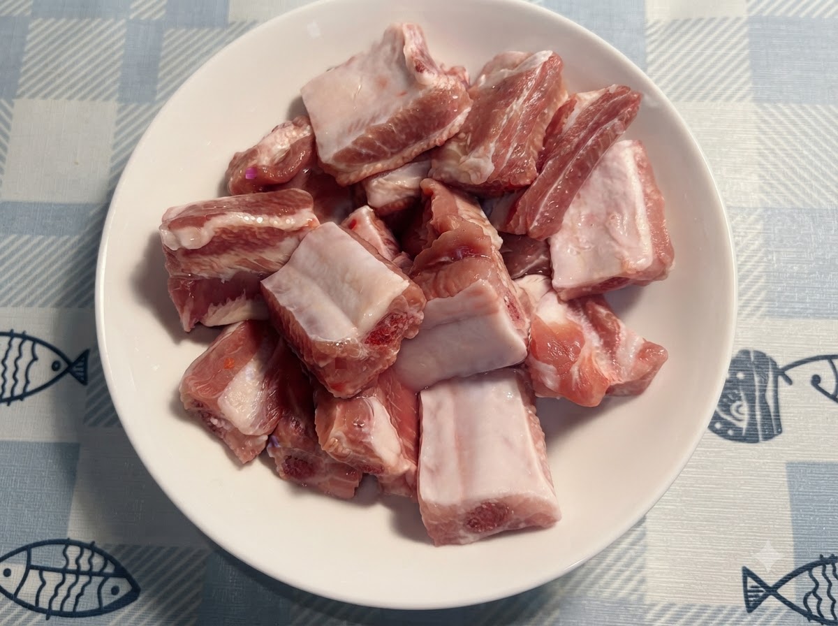 A small white spoon adding salt onto the raw pork ribs in the plate.