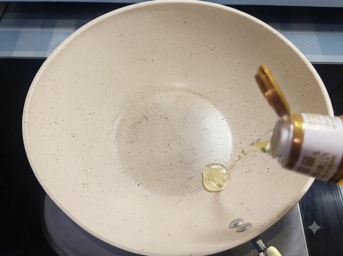 Cooking oil streaming from a bottle into a white ceramic frying pan.