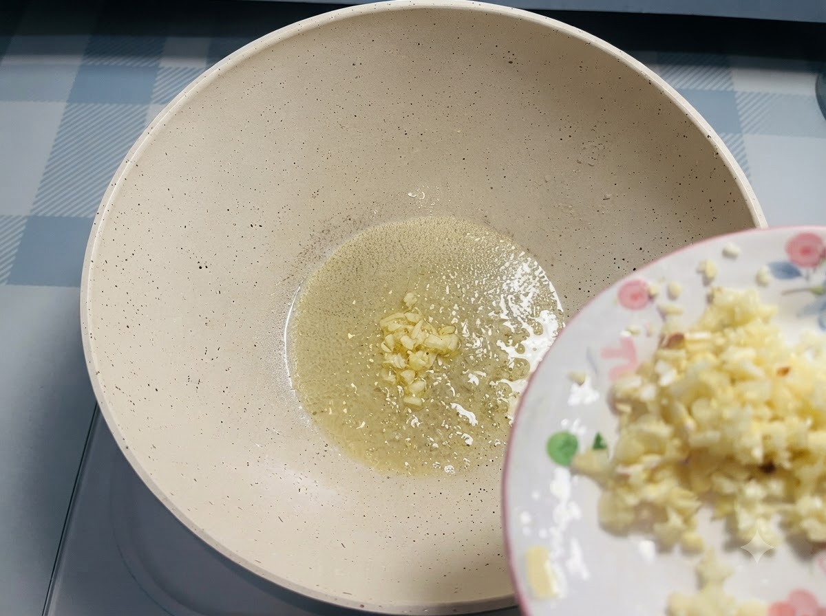 Minced garlic sliding from a small plate into melted butter in a pan.