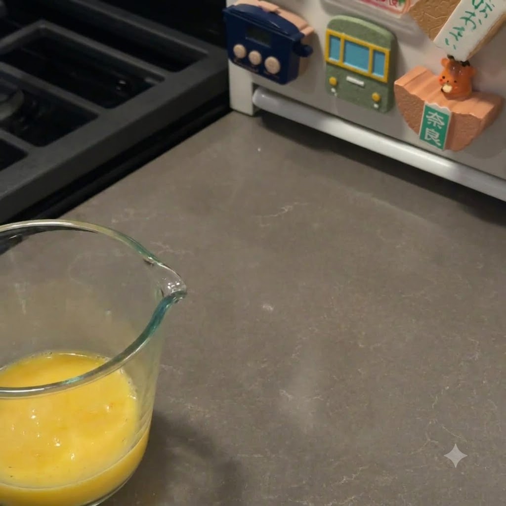 A pastry brush carefully coating the tops of proofed burger buns with an egg wash.